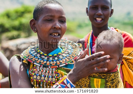 AMBOSELI, KENYA - OCTOBER 10, 2009: Unidentified Massai woman touches her baby\'s face in Kenya, Oct 10, 2009. Massai people are a Nilotic ethnic group