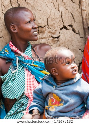 AMBOSELI, KENYA - OCTOBER 10, 2009: Unidentified Massai woman holds her litle baby on her knees in Kenya, Oct 10, 2009. Massai people are a Nilotic ethnic group