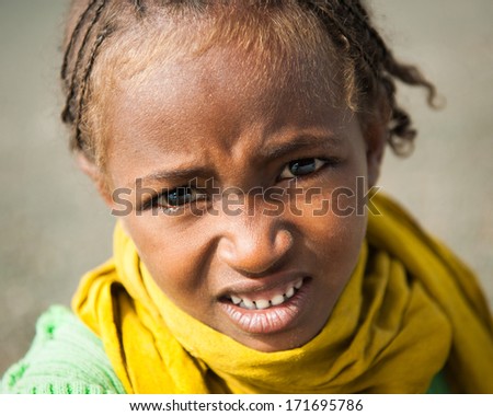 OMO VALLEY, ETHIOPIA - SEPTEMBER 19, 2011: Unidentified Ethiopian girl in a yellow scarf looks uo in Ethiopia, Sep.19, 2011. People in Ethiopia suffer of poverty due to the unstable situation