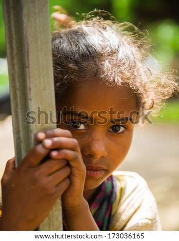 AKSUM, ETHIOPIA - SEP 30, 2011: Portrait of an unidentified Ethiopian cute little girl stays at the porch in Ethiopia, Sep.30, 2011. People in Ethiopia suffer of poverty due to the unstable situation