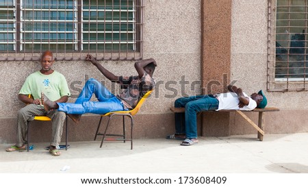 KARA, TOGO - MARCH 7, 2012: Unidentified Togolese men think, sleep and sit in the street in Togo, Mar 7, 2012. People in Togo suffer of poverty due to unstable economical situation
