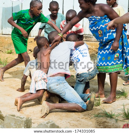 LIBREVILLE, GABON - MAR 6, 2013: Unidentified Gabonese woman tries to calm down the fighting children in Gabon, Mar 6, 2013. People of Gabon suffer of poverty due to the unstable economical situation