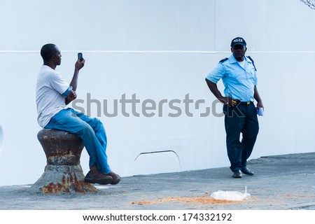 LIBREVILLE, GABON - MAR 6, 2013: Unidentified Gabonese man takes pictures of a locan police man in Gabon, Mar 6, 2013. People of Gabon suffer of poverty due to the unstable economical situation