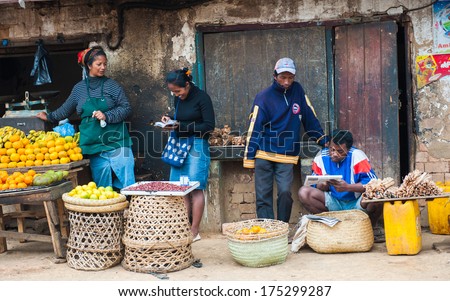 Antananarivo, Madagascar - June 29, 2011: Unidentified Madagascar Man And Woman Work At The Fruit Market. People In Madagascar Suffer Of Poverty Due To The Slow Development Of The Country