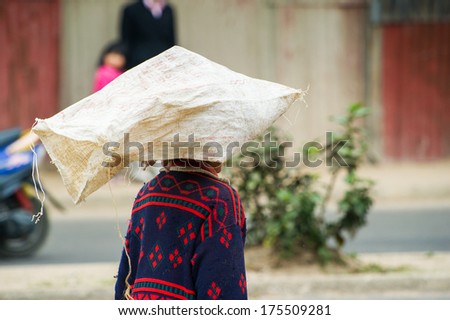 ANTANANARIVO, MADAGASCAR - JUNE 28, 2011: Unidentified Madagascar woman carries a bag on her head. People in Madagascar suffer of poverty due to the slow development of the country