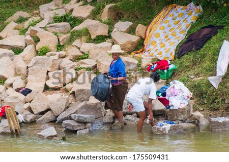 ANTANANARIVO, MADAGASCAR - JUNE 28, 2011: Unidentified Madagascar people clean and dry clothes in a river. People in Madagascar suffer of poverty due to the slow development of the country