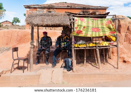 ANTANANARIVO, MADAGASCAR - JULY 1, 2011: Unidentified Madagascar men sell fruits. People in Madagascar suffer of poverty due to slow development of the country