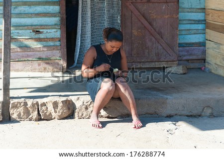 ANTANANARIVO, MADAGASCAR - JULY 3, 2011: Unidentified Madagascar woman eats yogurt. People in Madagascar suffer of poverty due to slow development of the country