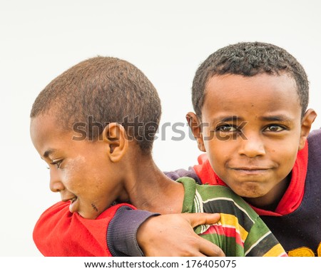 OMO, ETHIOPIA - SEPTEMBER 19, 2011: Unidentified Ethiopian cute kids friends hug each other. People in Ethiopia suffer of poverty due to the unstable situation
