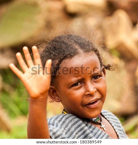 AKSUM, ETHIOPIA - SEPTEMBER 24, 2011: Unidentified Ethiopian beautiful girl waves her hand. People in Ethiopia suffer of poverty due to the unstable situation