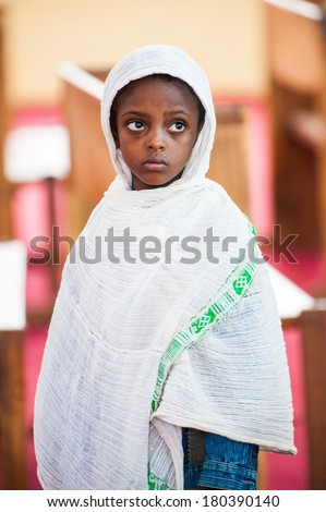AKSUM, ETHIOPIA - SEPTEMBER 24, 2011: Unidentified Ethiopian little girl wears the white tissue. People in Ethiopia suffer of poverty due to the unstable situation