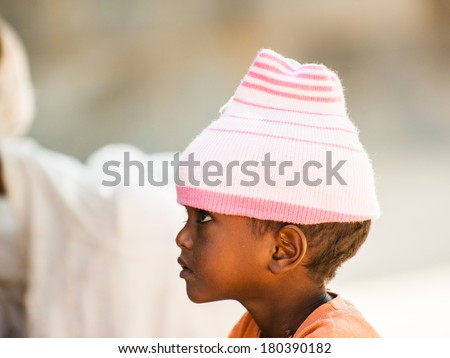 AKSUM, ETHIOPIA - SEPTEMBER 24, 2011: Unidentified Ethiopian little girl wears the pink hat. People in Ethiopia suffer of poverty due to the unstable situation