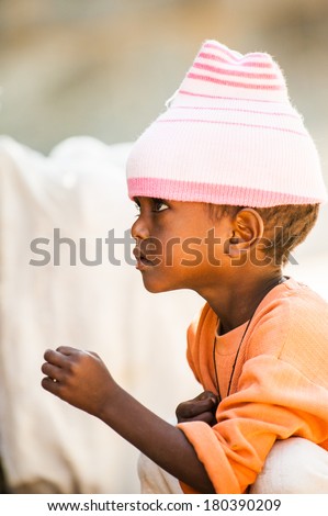 AKSUM, ETHIOPIA - SEPTEMBER 24, 2011: Unidentified Ethiopian little girl wears the pink hat. People in Ethiopia suffer of poverty due to the unstable situation