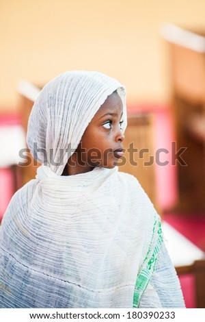 AKSUM, ETHIOPIA - SEPTEMBER 24, 2011: Unidentified Ethiopian little girl wears the white tissue. People in Ethiopia suffer of poverty due to the unstable situation