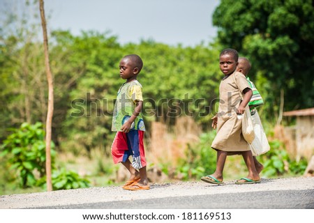 PORTO-NOVO, BENIN - MAR 8, 2012: Unidentified Beninese children run in the street. People of Benin suffer of poverty due to the difficult economic situation.