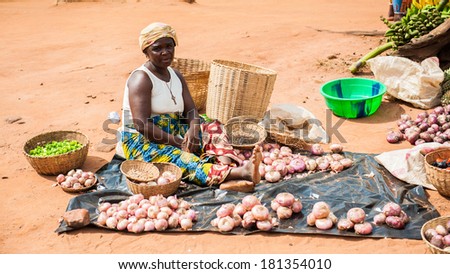 PORTO-NOVO, BENIN - MAR 9, 2012: Unidentified Beninese woman sells garlic at the local market. People of Benin suffer of poverty due to the difficult economic situation.