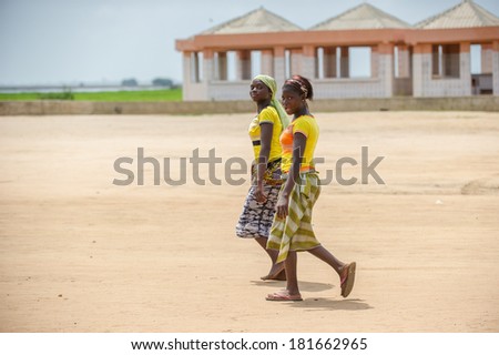 PORTO-NOVO, BENIN - MAR 9, 2012: Unidentified Beninese two women walks over the coast. People of Benin suffer of poverty due to the difficult economic situation.