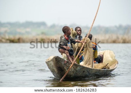 PORTO-NOVO, BENIN - MAR 9, 2012: Unidentified Beninese man and little boy work as a team to get fish. People of Benin suffer of poverty due to the difficult economic situation.