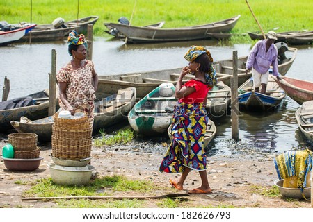 PORTO-NOVO, BENIN - MAR 9, 2012: Unidentified Beninese  woman talks to another woman on the coast. People of Benin suffer of poverty due to the difficult economic situation.