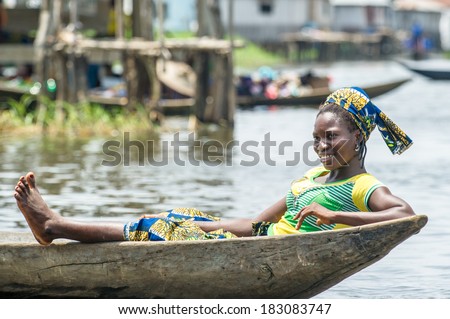 PORTO-NOVO, BENIN - MAR 9, 2012: Unidentified Beninese  woman lays in a wooden boat. People of Benin suffer of poverty due to the difficult economic situation.