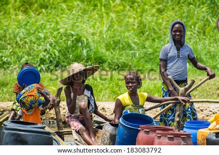PORTO-NOVO, BENIN - MAR 9, 2012: Unidentified Beninese people talk in wooden boats. People of Benin suffer of poverty due to the difficult economic situation.