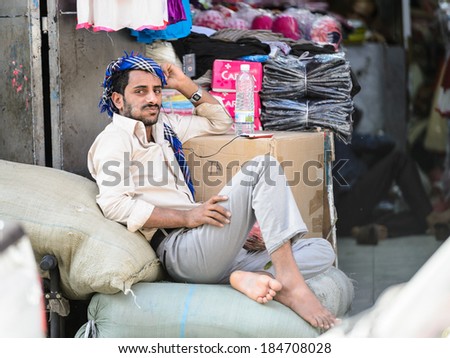 SANA\'A, YEMEN - JAN 11, 2014: Portrait of an unidentified man worling at market and listening music in Sana\'a, Yemen. People in Yemen live in poverty and without education