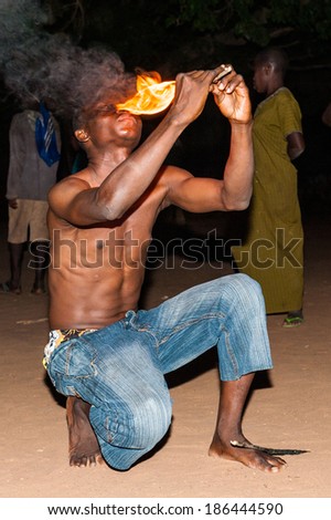 LOME, TOGO - MAR 7, 2012: unidentified Togolese man eats fire for the fire show performance. People in Togo suffer of poverty due to a difficult economical situation