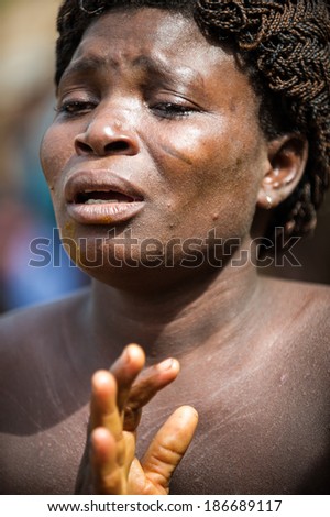 KARA, TOGO - MAR 11, 2012:  Unidentified Togolese woman in a traditional dress dances the religious voodoo dance. Voodoo is the West African religion