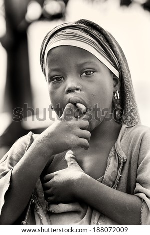 ACCRA, GHANA - MAR 5, 2012: Unidentified Ghanaian girl with a white paste on her tongue. People of Ghana suffer of poverty due to the difficult economic situation