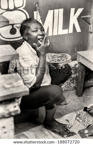 ACCRA, GHANA - MAR 4, 2012: Unidentified Ghanaian woman eats  in the street. People of Ghana suffer of poverty due to the difficult economic situation