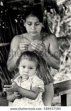 AMAZONIA, PERU - NOV 10, 2010: Unidentified Amazonian  woman and her daughter. Indigenous people of Amazonia are protected by COICA (Coordinator of Indigenous Organizations of the Amazon River Basin)