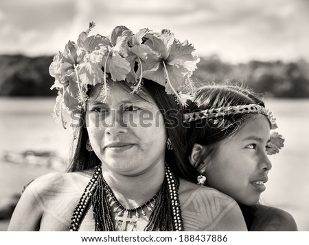 EMBERA VILLAGE, PANAMA, JANUARY 9, 2012: Unidentified native Indian woman and her daughter with flowers on the hair. Indian reservation is the way to conserve native culture, language, traditions