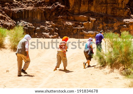 WADI RUM, JORDAN - APR 30, 2014: Unidentified tourists walk in the Wadi Rum valley. Wadi Rum valley is the UNESCO World Heritage site
