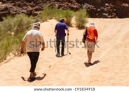 WADI RUM, JORDAN - APR 30, 2014: Unidentified tourists walk in the Wadi Rum valley. Wadi Rum valley is the UNESCO World Heritage site