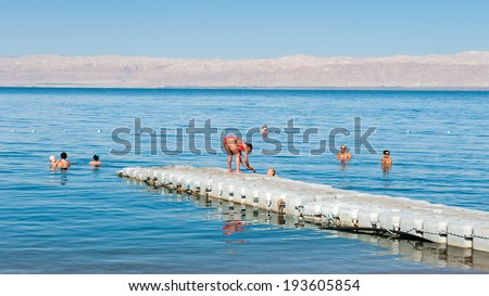 DEAD SEA RESORT, JORDAN - MAY 1, 2014: Unidentified people at the Beach at the Dead Sea coast in Jordan. Dead Sea water is used for medical purposes for the people with skin problems