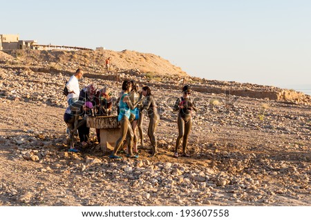 DEAD SEA RESORT, JORDAN - APR 30, 2014: Unidentified people put mud on their bodies. Dead Sea mud posesses the medical qualities