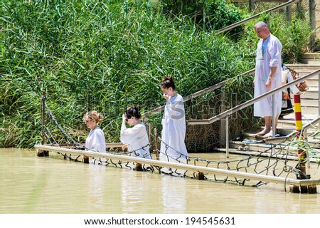 JESUS CHRIST BAPTISM SITE , ISRAEL - MAY 1, 2014: Unidentified women in the Sacred water of the River Jordan. River where Jesus of Nazareth was baptized by John the Baptist.