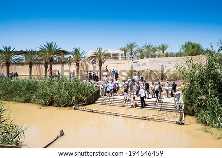 JESUS CHRIST BAPTISM SITE , ISRAEL - MAY 1, 2014: Unidentified people near the Sacred water of the River Jordan. River where Jesus of Nazareth was baptized by John the Baptist.