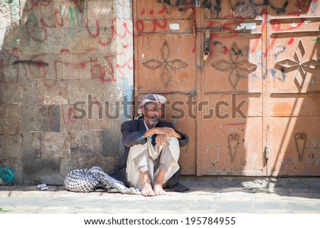 SANA\'A, YEMEN - JAN 11, 2014: Unidentified Yemeni old man sits in the street. People of Yemen suffer of poverty due to the unstable political and poor economical situation
