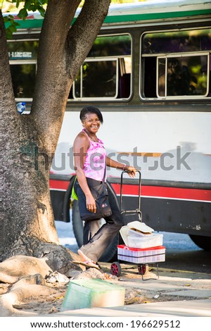 CARACAS, VENEZUELA - NOV 20, 2013: Unidentified Venezuelan woman stays near the bus in Caracas, Venezuela. 51,6% of people in Venezuela belong to the Mestizo ethnic group