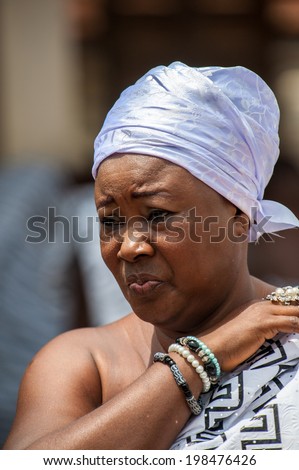 ACCRA, GHANA - MARCH 4, 2012: Unidentified Ghanaian woman watches the  local street music show in Ghana. People of Ghana suffer of poverty due to the unstable economic situation