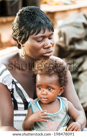 ACCRA, GHANA - MARCH 5, 2012: Unidentified Ghanaian baby boy on his mother lap in the street in Ghana. Children of Ghana suffer of poverty due to the unstable economic situation