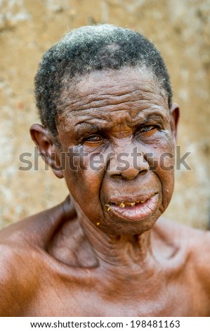 ACCRA, GHANA - MARCH 6, 2012: Unidentified Ghanaian toothless old lady smiles in the street in Ghana. People of Ghana suffer of poverty due to the unstable economic situation