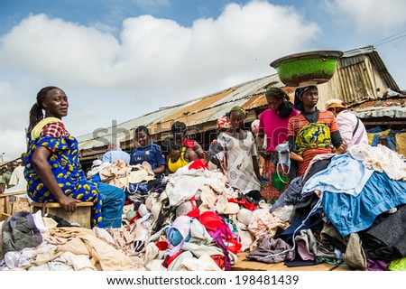 ACCRA, GHANA - MARCH 4, 2012: Unidentified Ghanaian womaen at the clothes market in Ghana. People of Ghana suffer of poverty due to the unstable economic situation