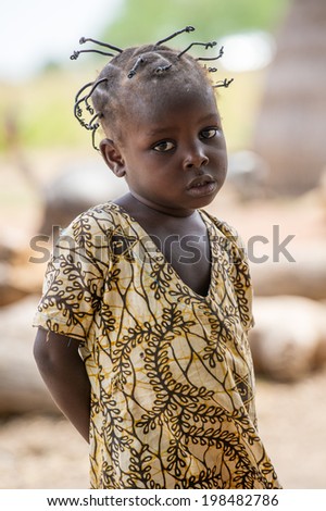 ACCRA, GHANA - MARCH 6, 2012: Unidentified Ghanaian beautiful girl with nive haircut in the street in Ghana. Children of Ghana suffer of poverty due to the unstable economic situation