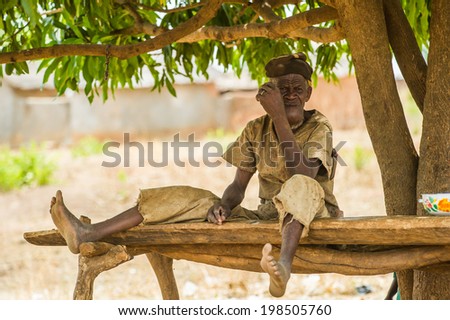 ACCRA, GHANA - MARCH 6, 2012: Unidentified Ghanaian old man with cigarette and a hat in the street in Ghana. People of Ghana suffer of poverty due to the unstable economic situation