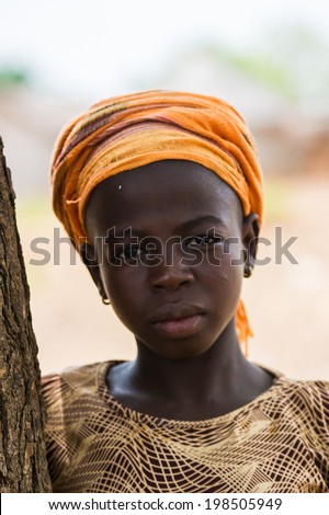 ACCRA, GHANA - MARCH 6, 2012: Unidentified Ghanaian woman near the tree in the street in Ghana. People of Ghana suffer of poverty due to the unstable economic situation