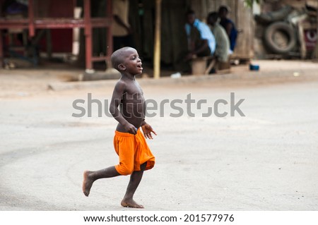 ACCRA, GHANA - MARCH 2, 2012: Unidentified Ghanaian boy runs in the street in Ghana. People of Ghana suffer of poverty due to the unstable economic situation