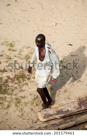 ACCRA, GHANA - MARCH 2, 2012: Unidentified Ghanaian man walks on the coast of Ghana. People of Ghana suffer of poverty due to the unstable economic situation