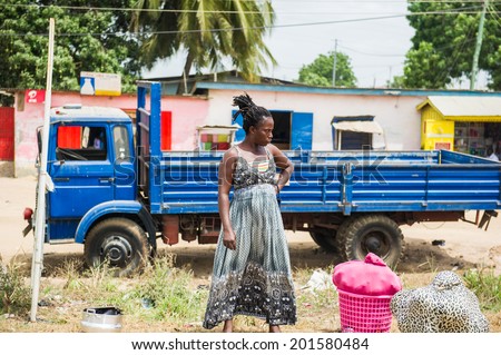 ACCRA, GHANA - MARCH 2, 2012: Unidentified Ghanaian woman stays in front of a truck in the street in Ghana. People of Ghana suffer of poverty due to the unstable economic situation